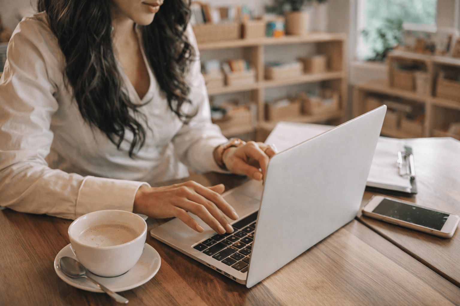 woman cozy in a her homeschool room working on computer with coffee cup next to her